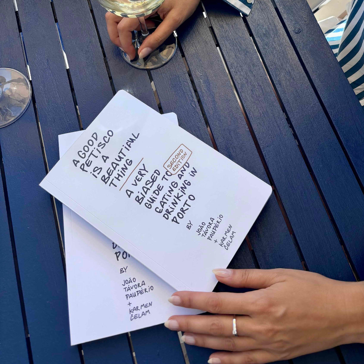 The Petiscos Porto Food Guidebook lying on a blue café table
