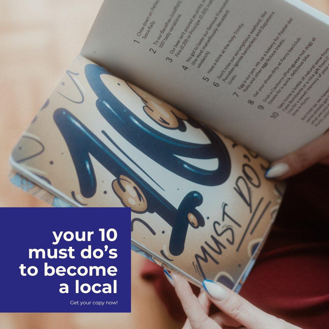 A book with food and drink recommendations held by a person with blue-tipped nails.